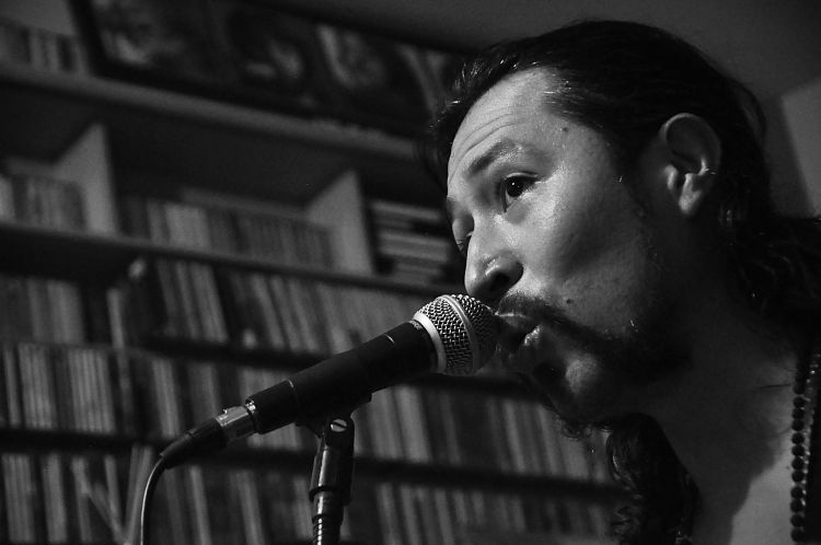 Un ensayo de Carlos Elliot Jr a blanco y negro cantando cerca al microfono