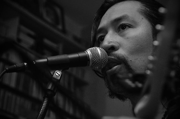 Un ensayo de Carlos Elliot Jr a blanco y negro foto en primer plano al lado del mircofono