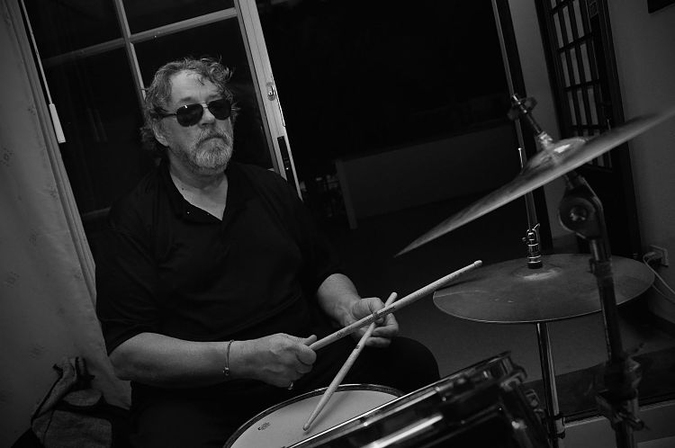 Un ensayo de Carlos Elliot Jr a blanco y negro tocando la bateria