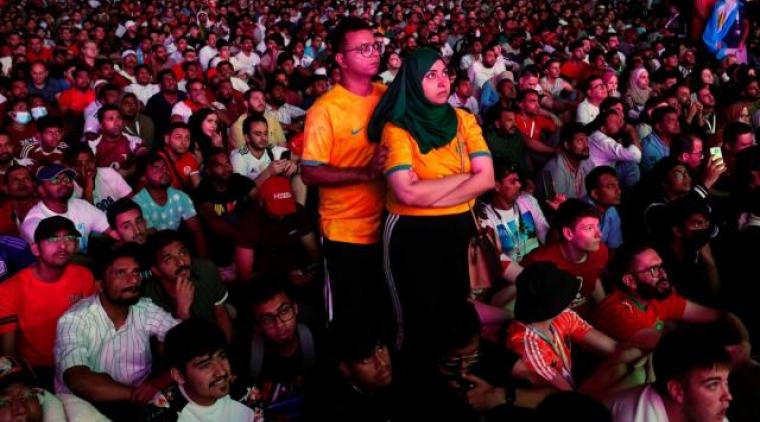 Miles de migrantes se reúnen a ver los partidos en una gran pantalla. Imagen de Yahoo. 